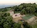 Aerial view of the Main Villa and Guest pavilion with terrace and tennis court among trees at Poggio Posillipo