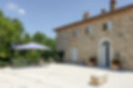 Stone villa and Piazzetta countryard with a blue parasol at Poggio Posillipo private borgo, Umbria