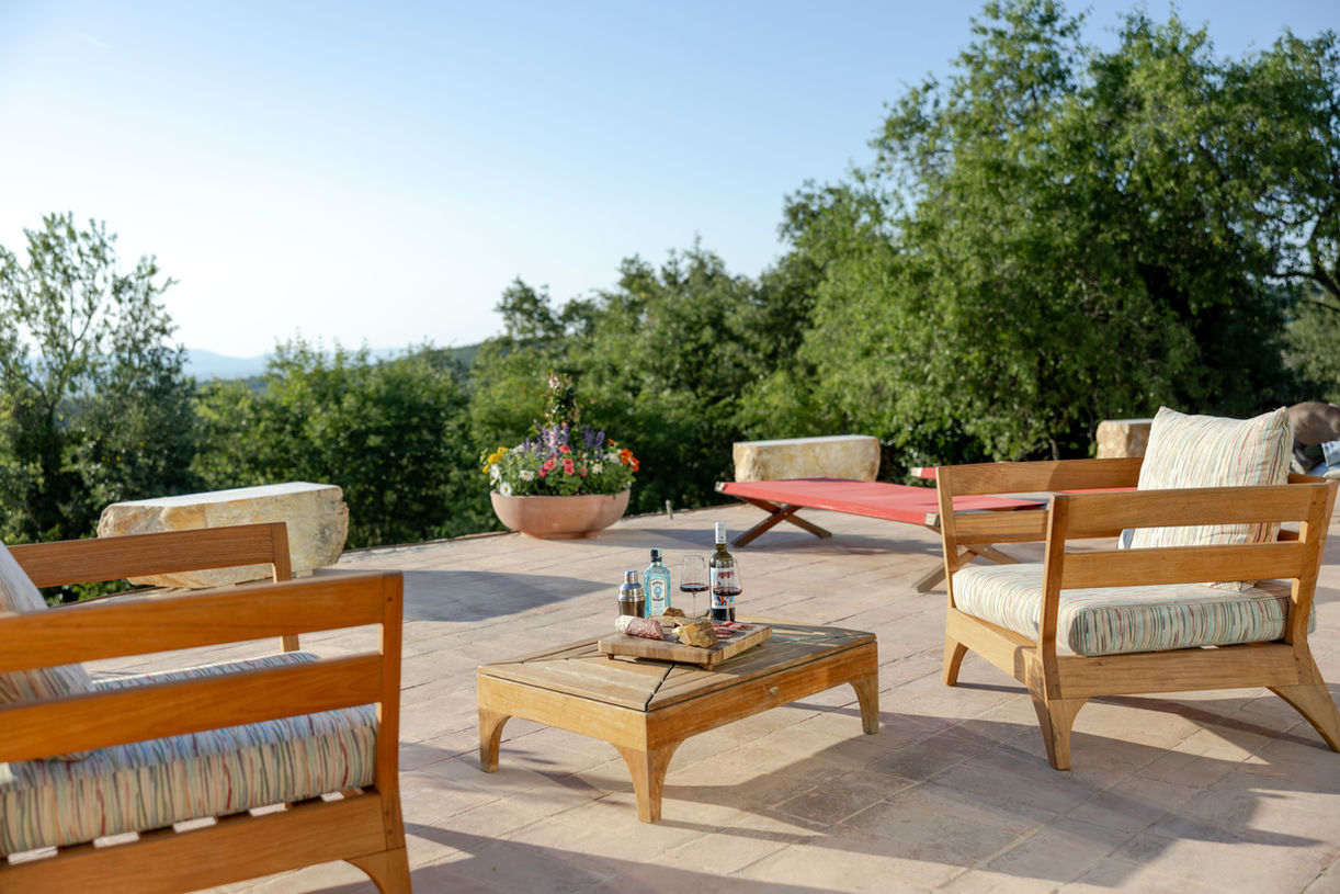 Sunny outdoor terrace with seating, table, and scenic view overlooking Umbrian countryside