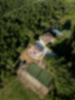 Aerial view of a villa with pool and tennis court among trees