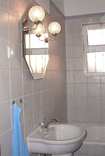 das Bad mit Duschbadewanne, Waschbecken und WC