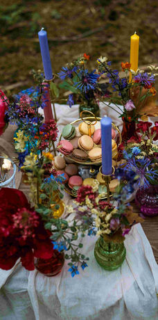 Tischdekoration mit vielen verschiedenen Farben als Kerzen und Vasen.