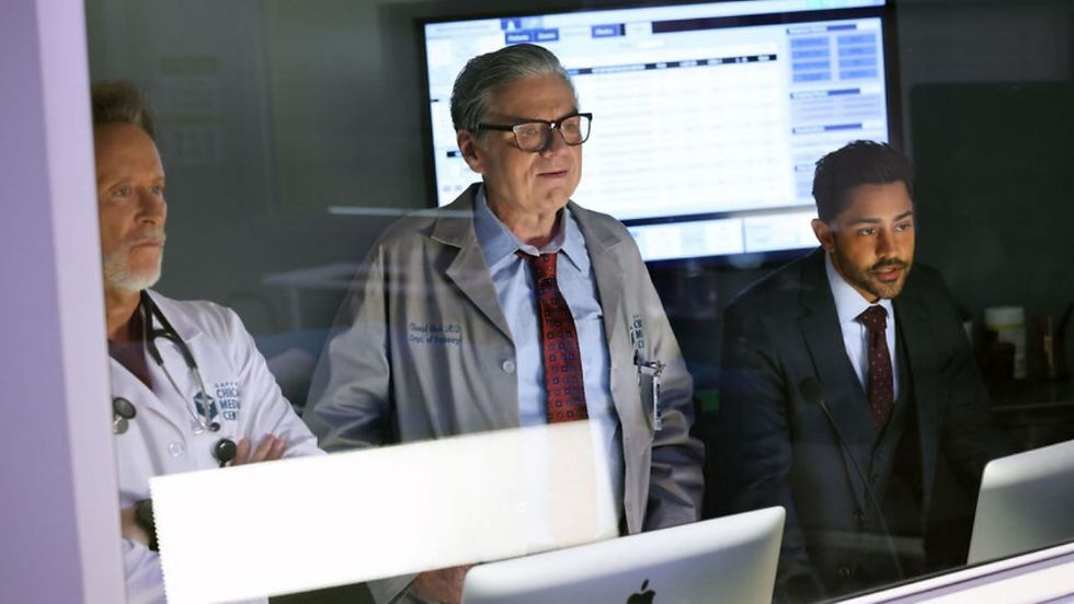 Manish Dayal as Dr. Theo Rabari collaborating with fellow doctors in a critical scene from Chicago Med Season 11.