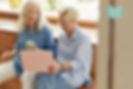 two middle aged women looking at a laptop