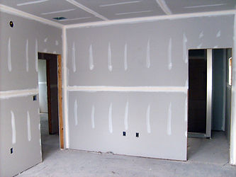 Unfinished room showing newly installed drywall.