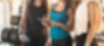Group of sporty female friends using app on mobile phone, looking at screen of smart phone