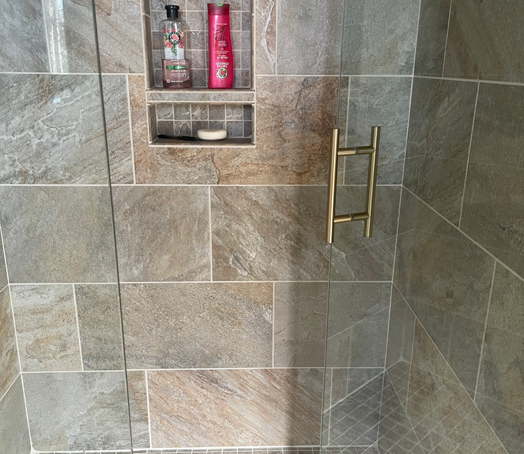 Custom tiled shower in Chattanooga, TN with double niche shelf, stone-look tile, and finished shower installation.