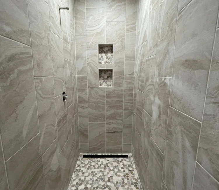 Curbless wheelchair-accessible shower tile installation in Chattanooga, TN with recessed niches, linear drain, and open-entry design for safer everyday use.