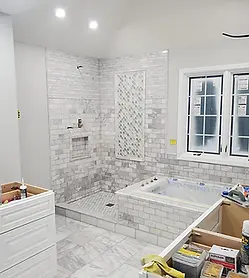 Luxury bathroom remodel in progress featuring a custom walk-in shower with mosaic tile accent, built-in niche, and marble flooring by Chattanooga Tile Company in Chattanooga, Tennessee.
