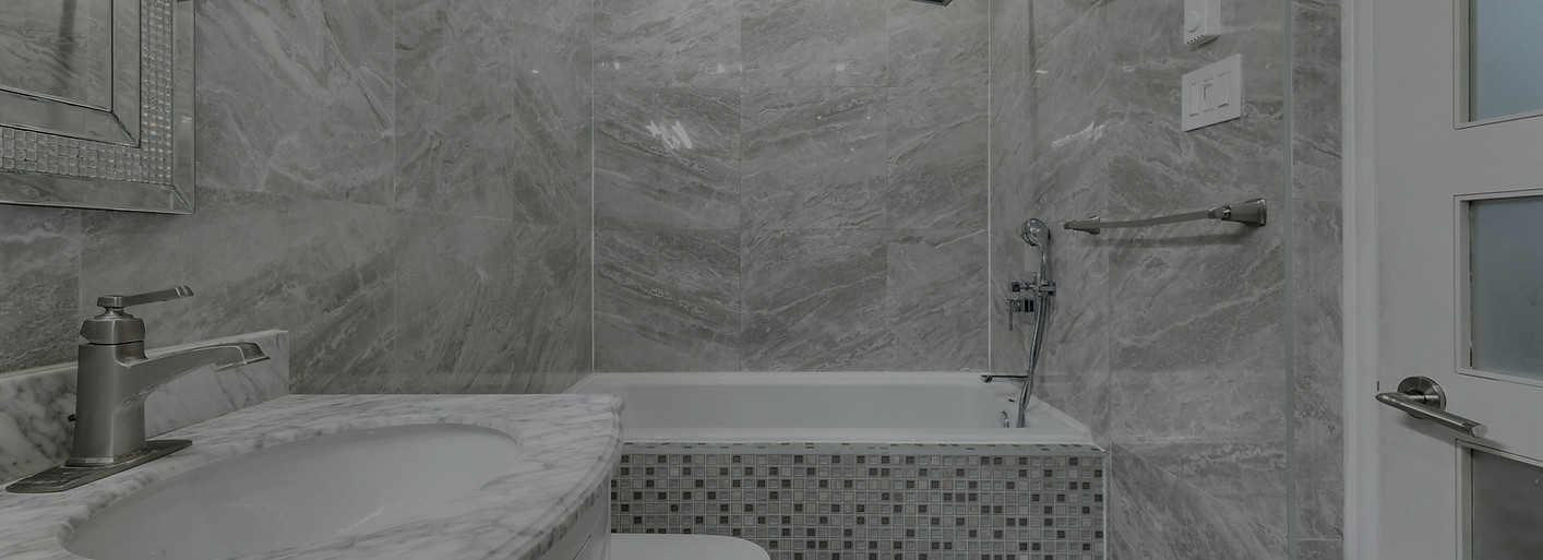 Modern bathroom remodel with marble-look tile walls, custom vanity, and mosaic tile bathtub by Chattanooga Tile Company in Chattanooga, Tennessee.