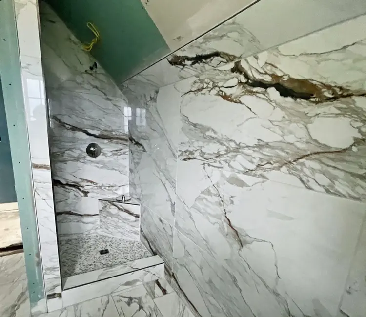 Custom tiled shower wall in Chattanooga, TN with marble-look tile and shower valve rough-in during installation.