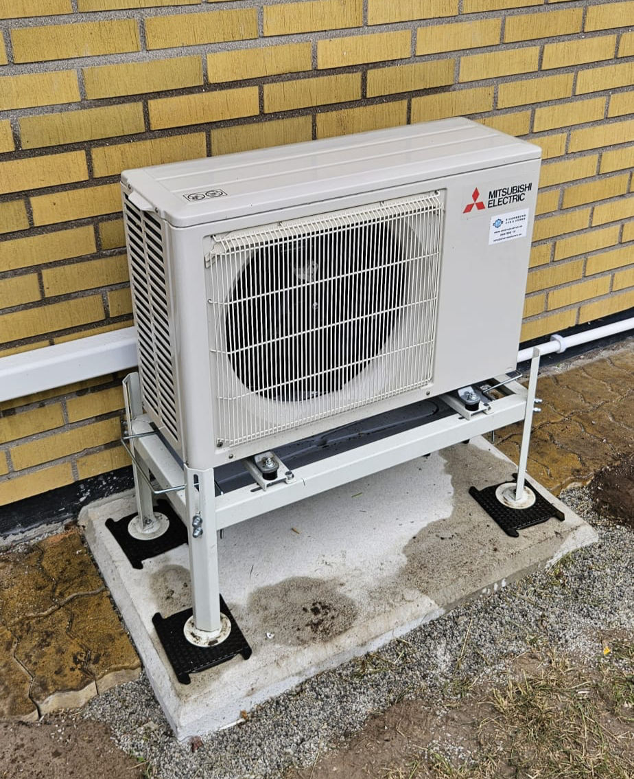 Professionell installation av Mitsubishi Electric värmepump i Kristianstad. Luft-luftvärmepump på markstativ vid villa med energieffektiv drift och låg ljudnivå året runt.