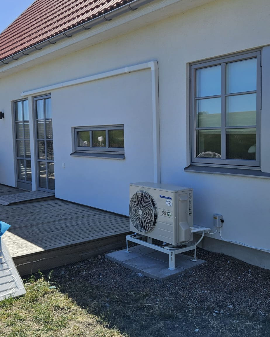 Professionell installation av Panasonic luft-vattenvärmepump i Kristianstad. Modern värmepump monterad på markstativ vid villa för lägre energikostnader och hög inomhuskomfort.