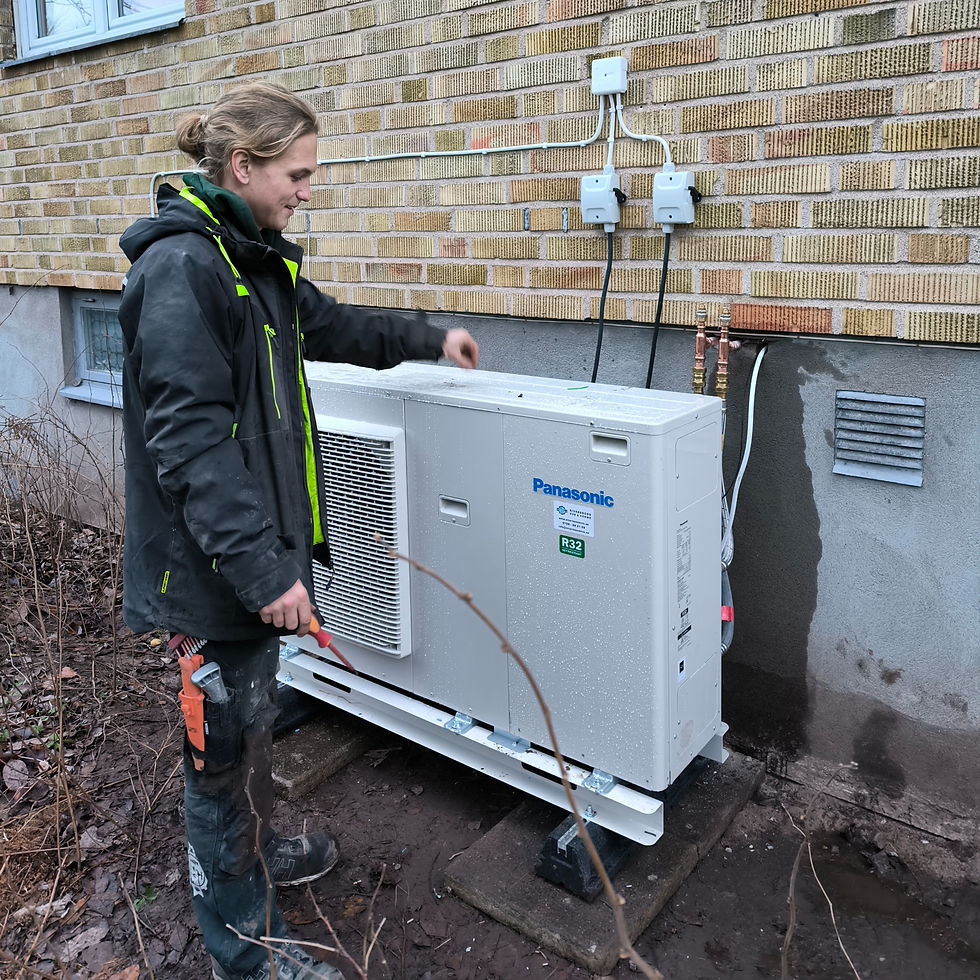 Montör från Siverssons VVS & Värme vid en nyinstallerad Panasonic luft/vatten-värmepump med R32-köldmedium utanför en villa i Kristianstad.