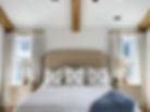 White and teal bed with white lamps next to the bed