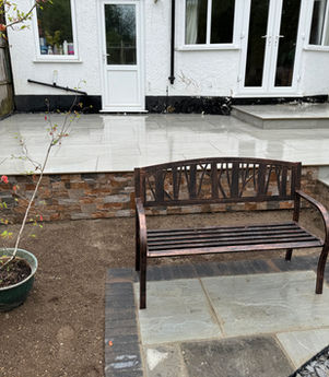 Angle view of curved block path alongside lawn and newly turfed area