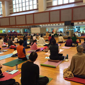 People sit on wood floor facing speaker at retreat