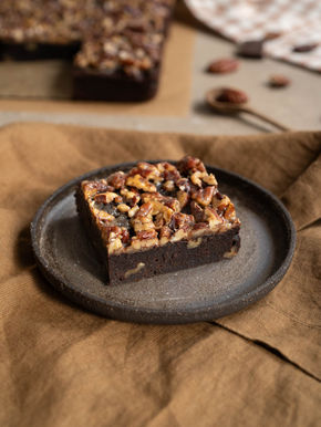 Pekannuss-Brownies mit fudgy Schokoladenboden und karamellisierten Pekannüssen als Topping, in quadratische Stücke geschnitten.