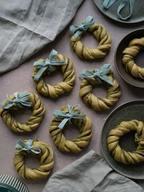 Kleine Hefekränze in leicht grüner Farbe, die an einen Adventskranz erinnern.