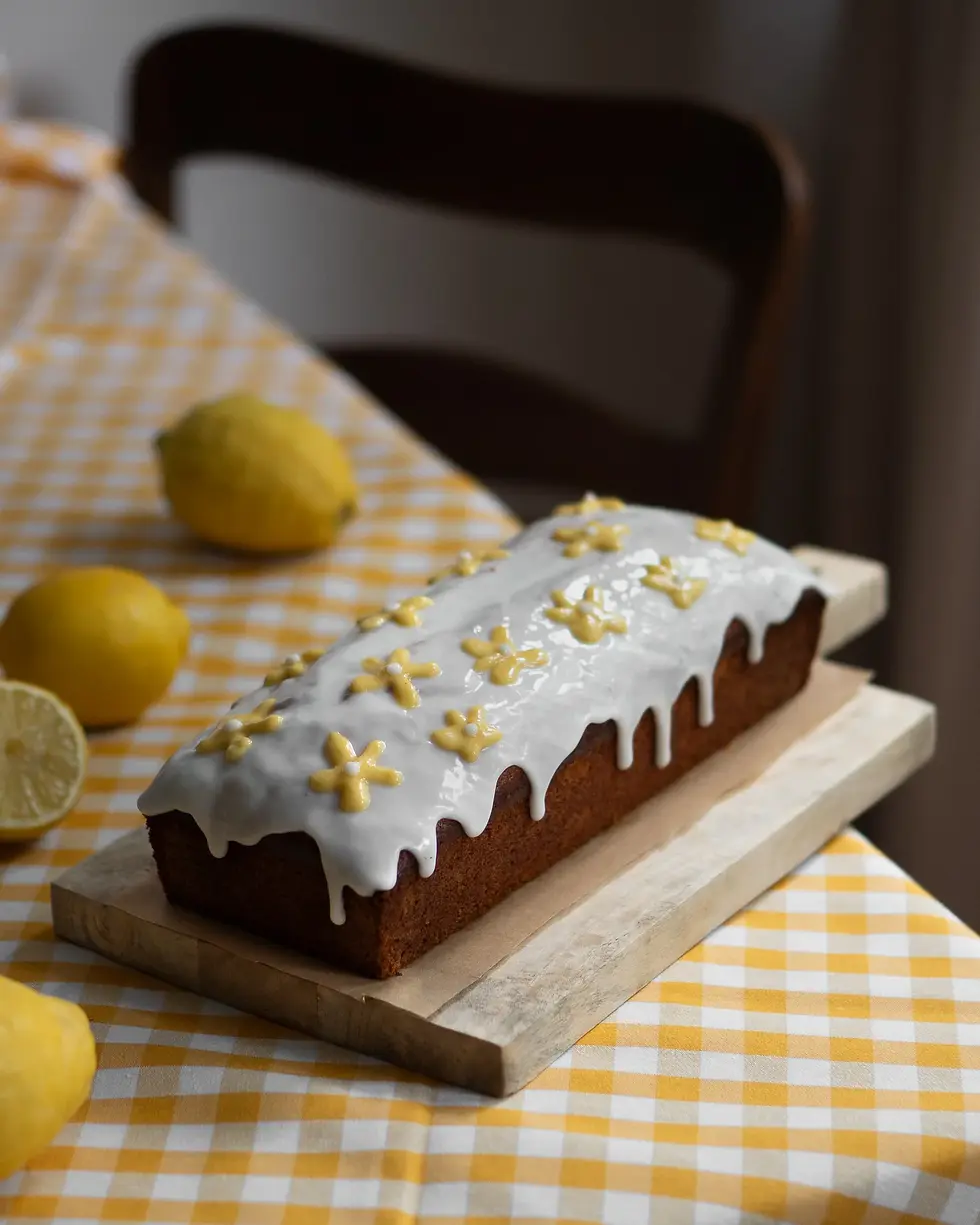 Ein Zitronen Kastenkuchen mit einer Puderzucker-Glasur dekoriert.