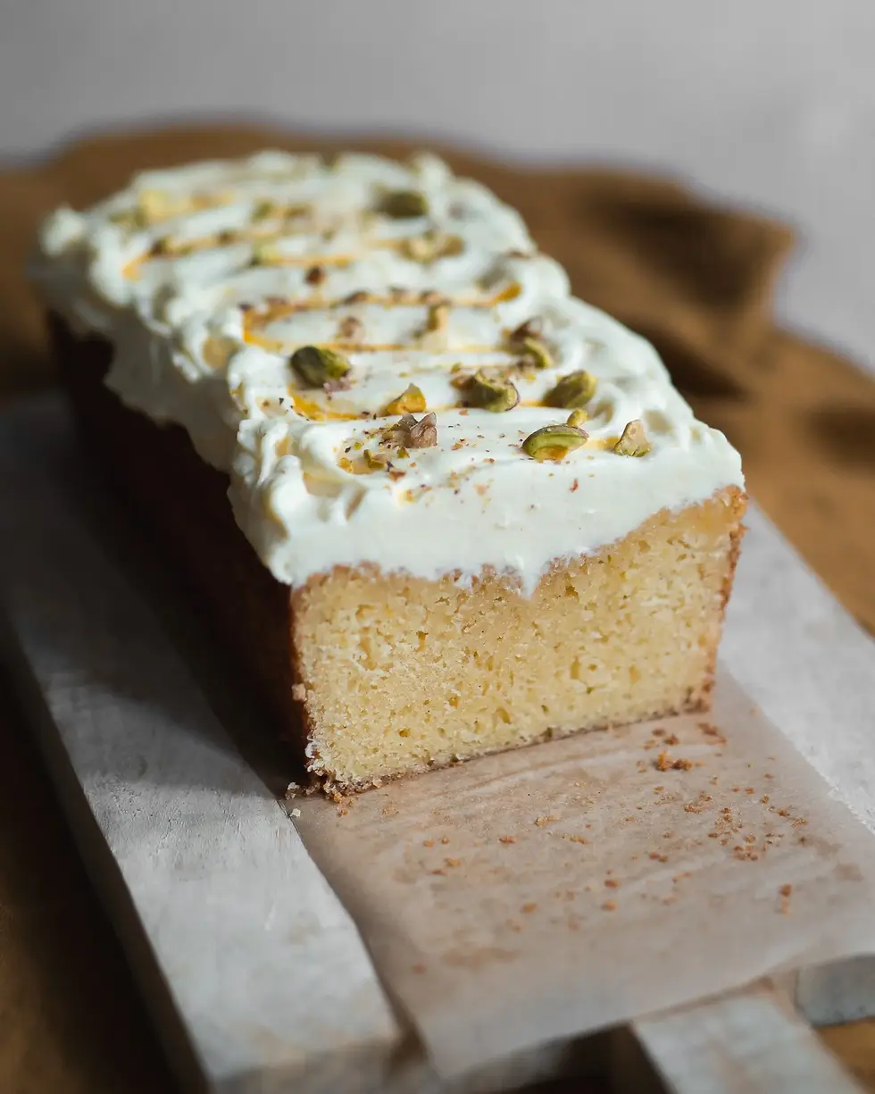 Ein angeschnittener Maracuja Kastenkuchen mit schöner Textur und Frischkäse Frosting on top.