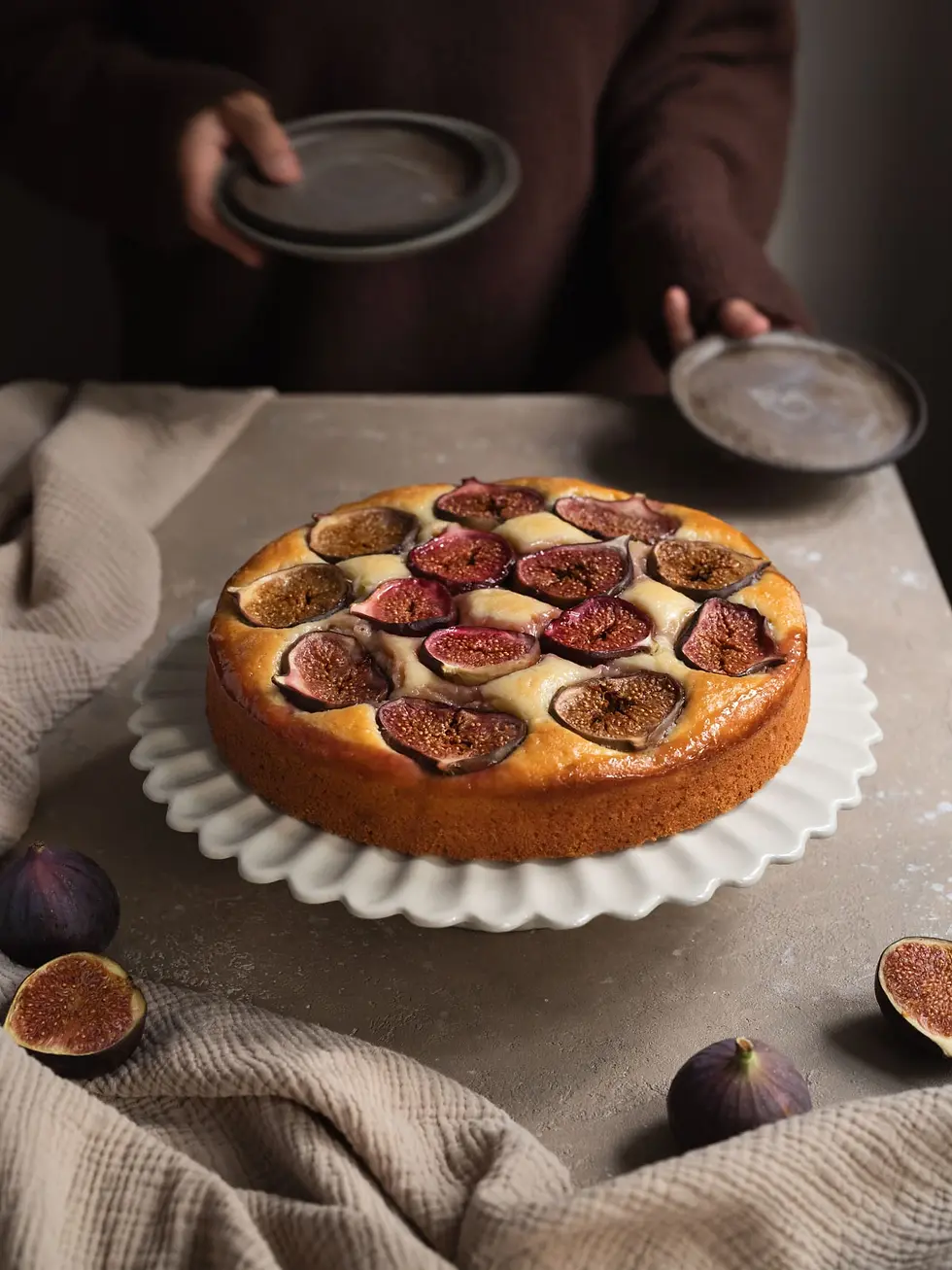 Ricotta-Feigen Kuchen mit gebackenen Feigen auf einer weißen Tortenplatte.