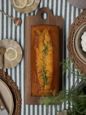 Saftiger Maiskuchen mit Olivenöl, Honig, Zitrone und Rosmarin, serviert mit zitroniger Ricotta-Creme und frischem Rosmarin.