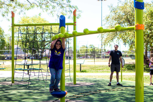 Student playing on monkey bars at Dee Park Playground