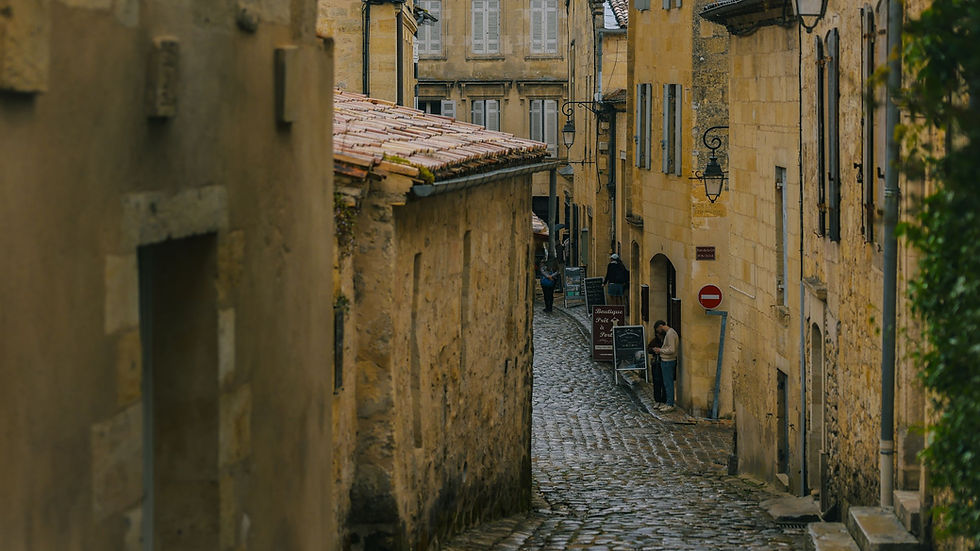 A narrow cobbled street of stone buildings in Saint-Emilion, France, representing a different legal and succession system.