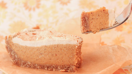 A slice of frozen pumpkin pie with a bite on a fork