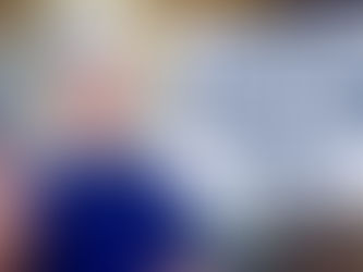 Man in blue shirt meditates, eyes closed, in vibrant setting. Text: "Who am I? What do I want? Return to your divine self & play!"