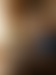 Man in a cozy room, typing on a laptop in an armchair. Sunlit window, bookshelves, plants. Swirling light trails create a magical mood.