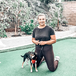 woman holding slip lead with small dog.