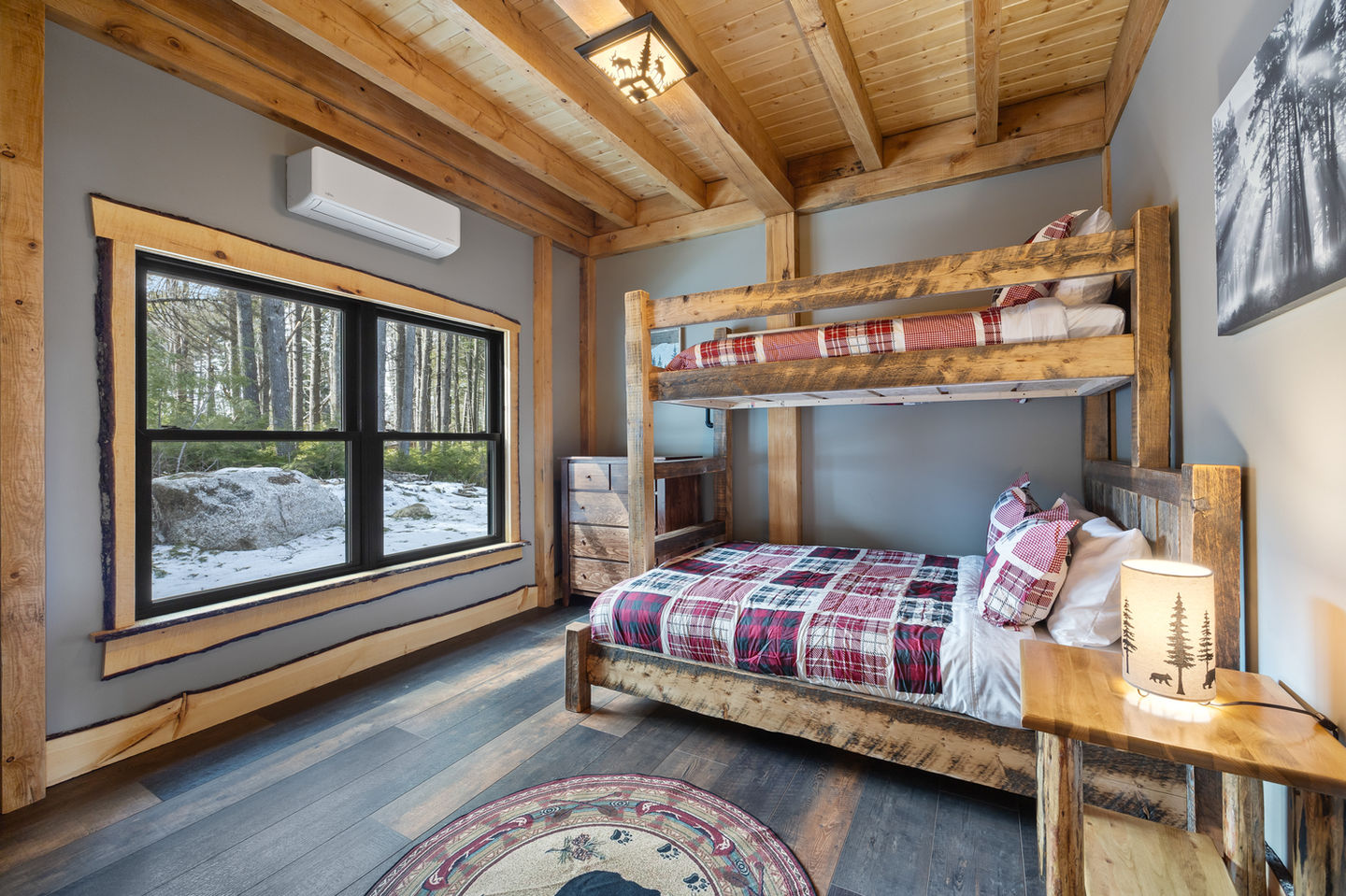 Cozy bedroom with wooden bunk beds and window view.