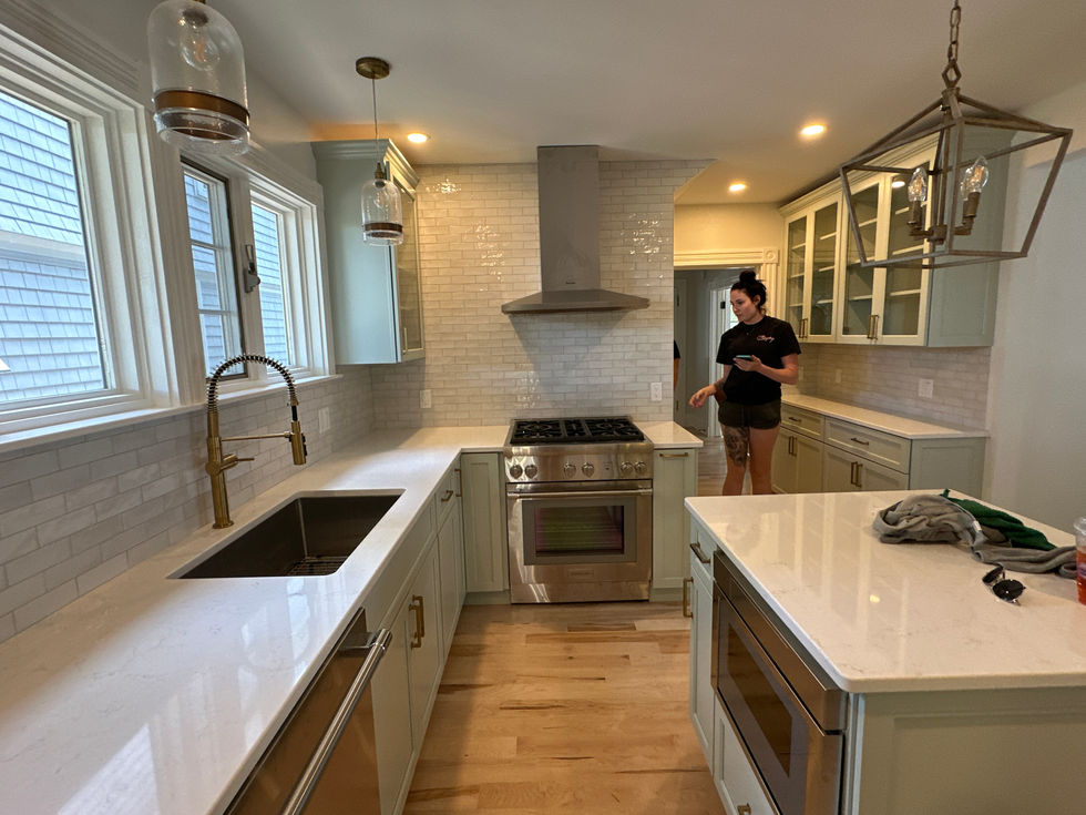 Modern kitchen with white countertops and stainless steel appliances.