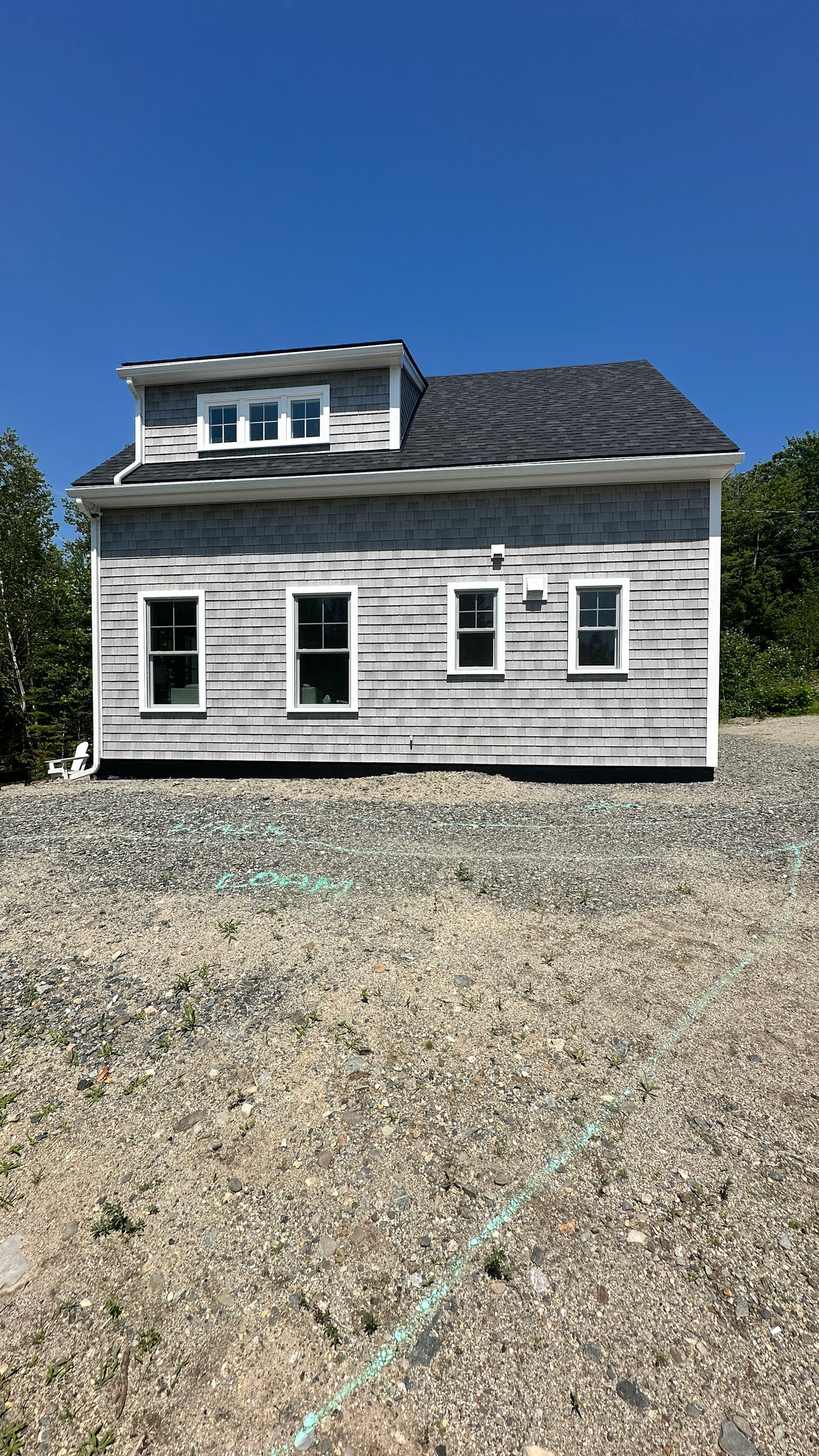 Gray house with white trim and three windows.
