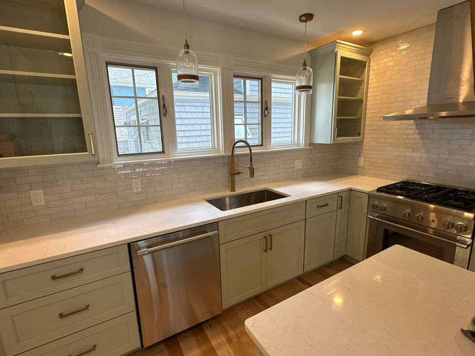Modern kitchen with white cabinets and stainless steel appliances.