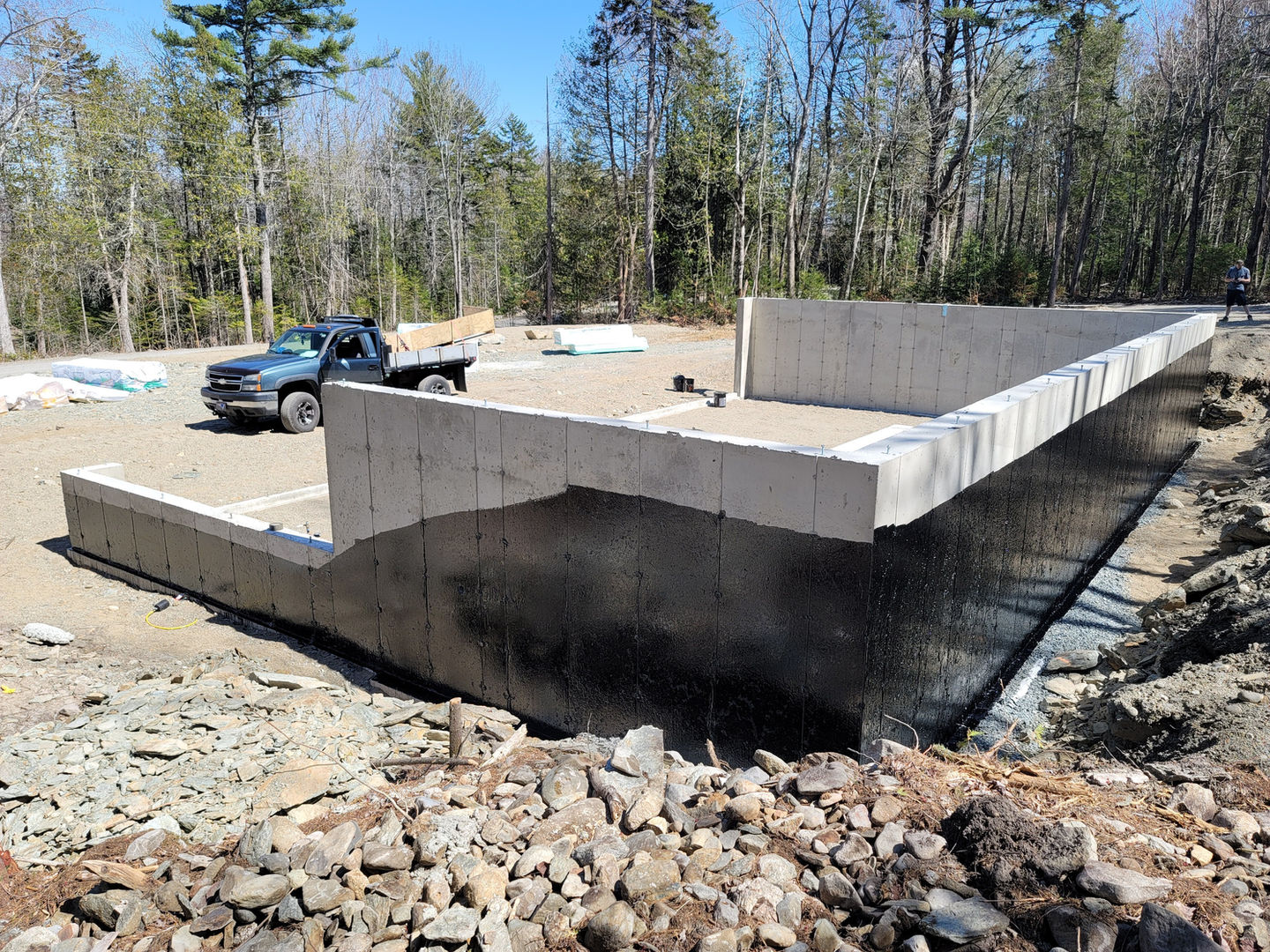 Concrete foundation with truck in wooded area.