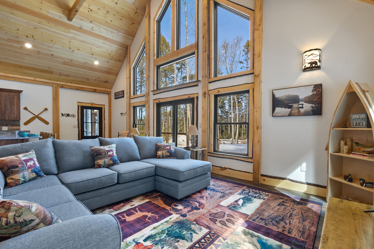 Cozy living room with large windows and colorful rug.