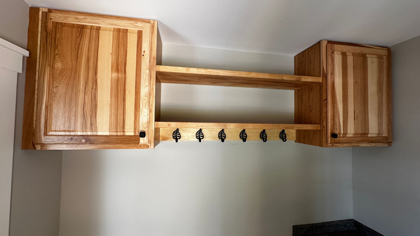 Wooden wall-mounted shelf with wine glass holders.