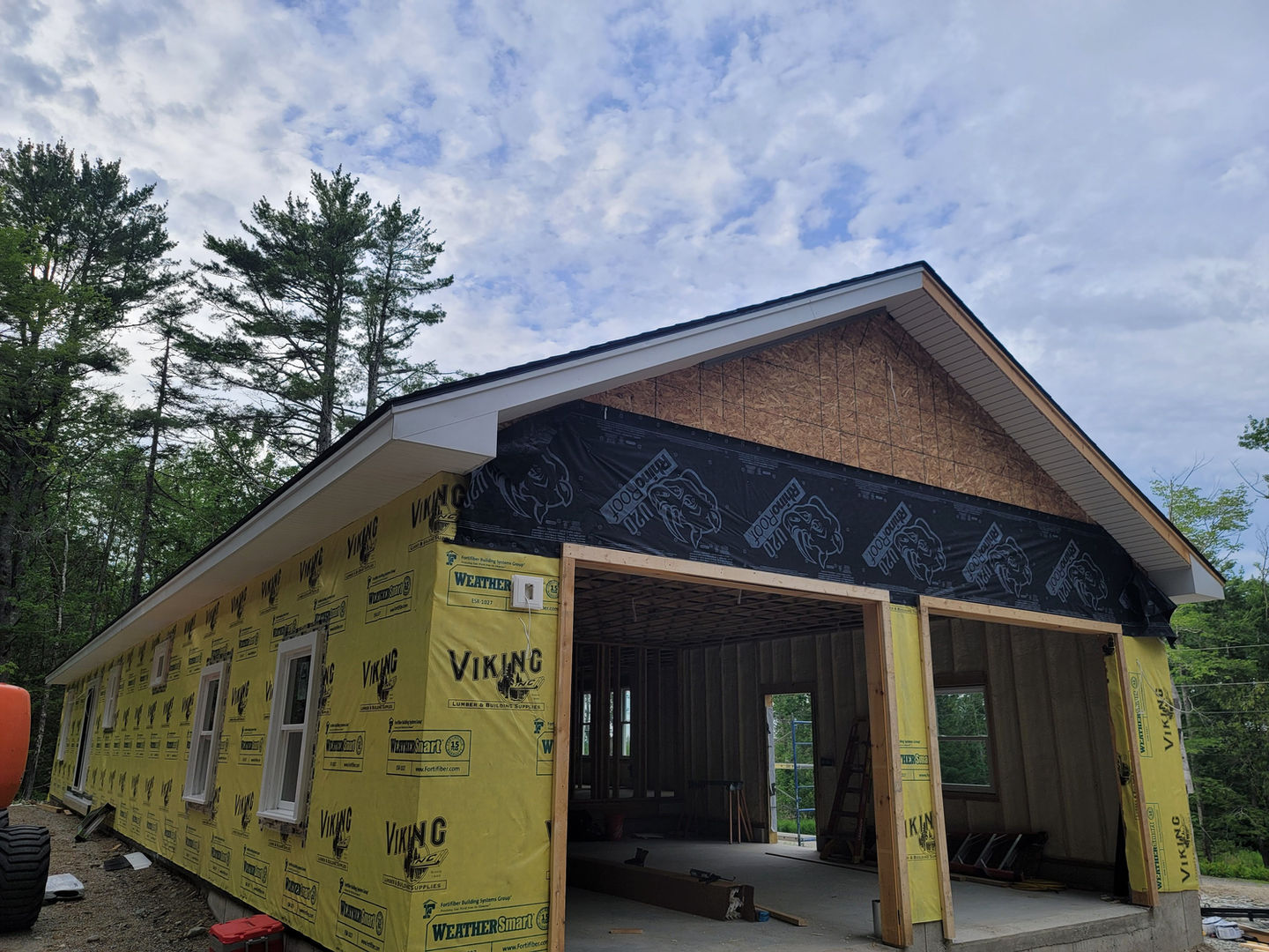 House under construction with yellow insulation wrap.