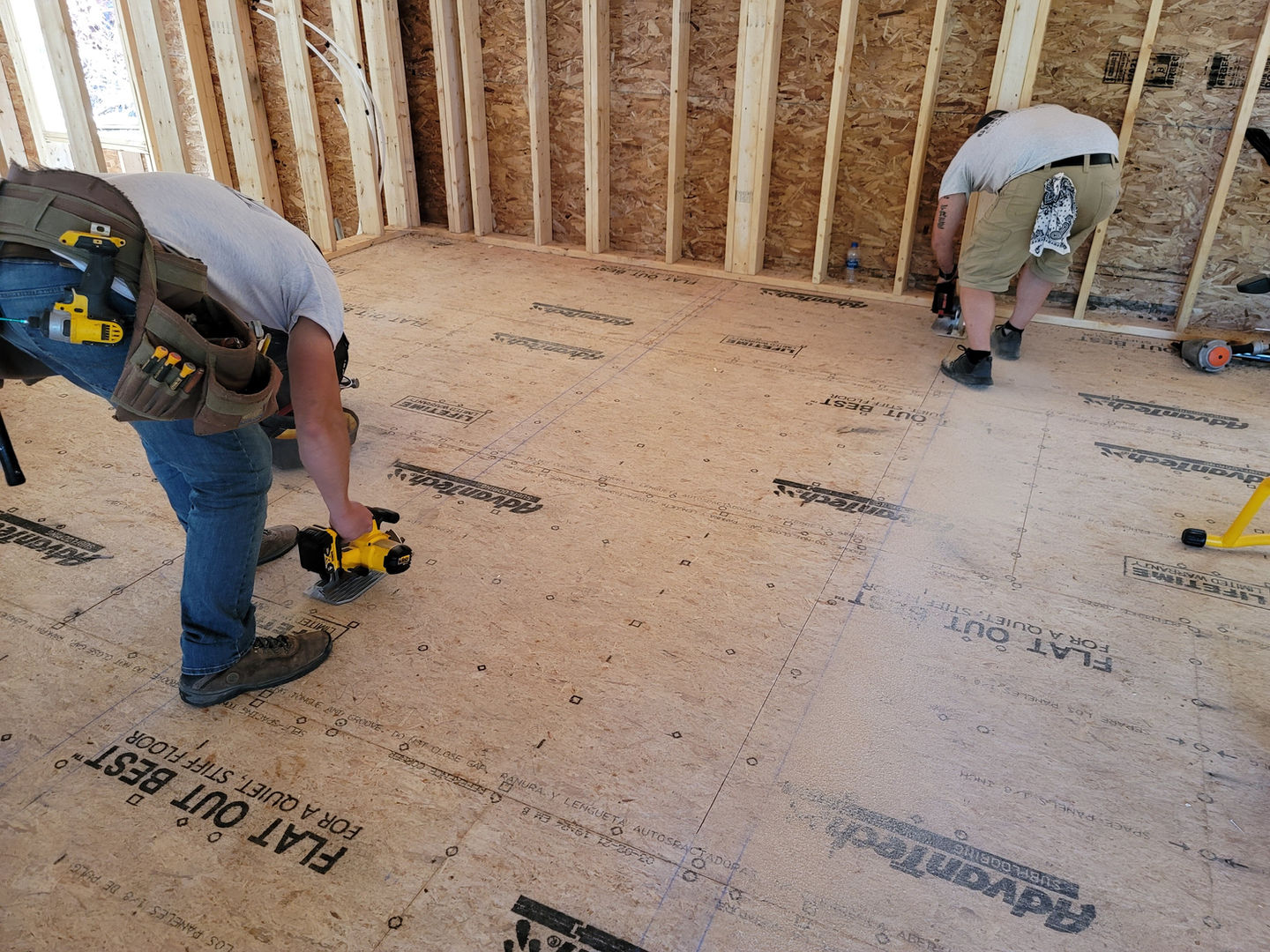 Two people working on construction flooring.