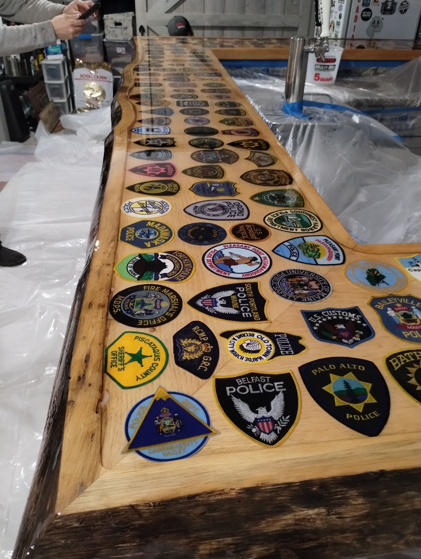 Wooden table with various patches displayed on top.
