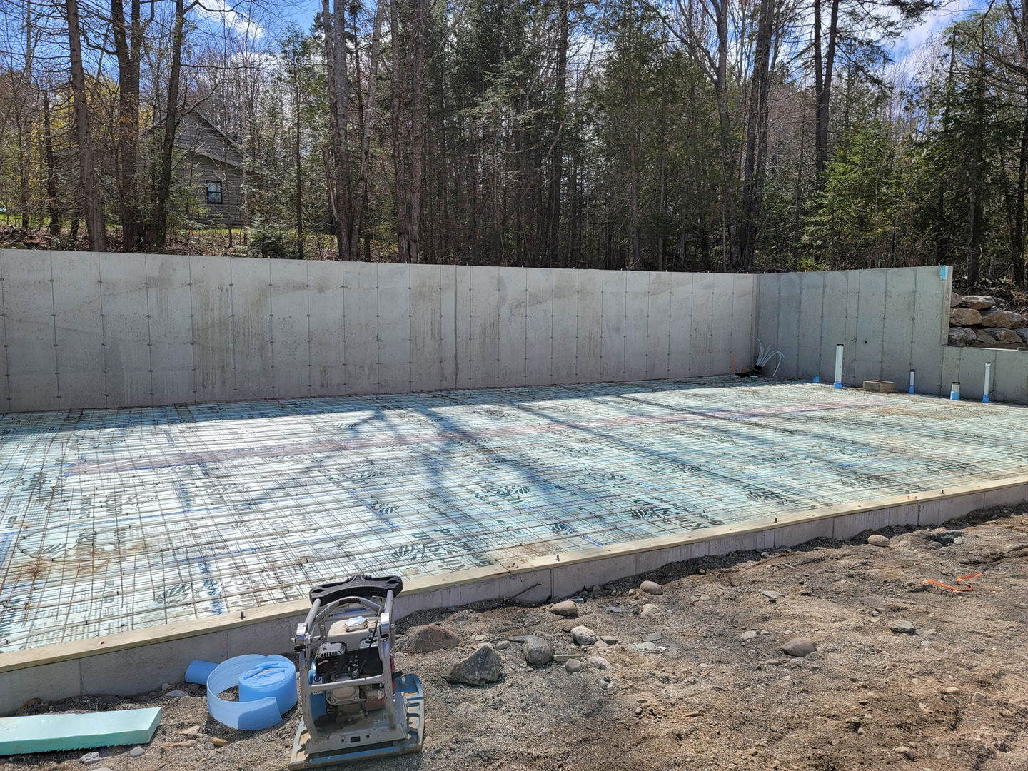 Concrete foundation with surrounding forest background.