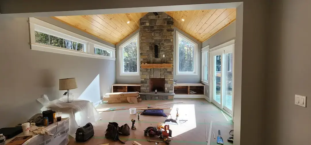 Cozy living room with stone fireplace and wooden ceiling.
