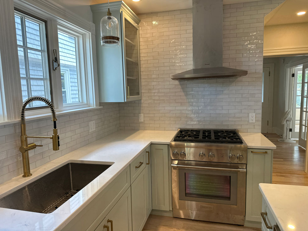 Modern kitchen with stainless steel appliances and white cabinets.