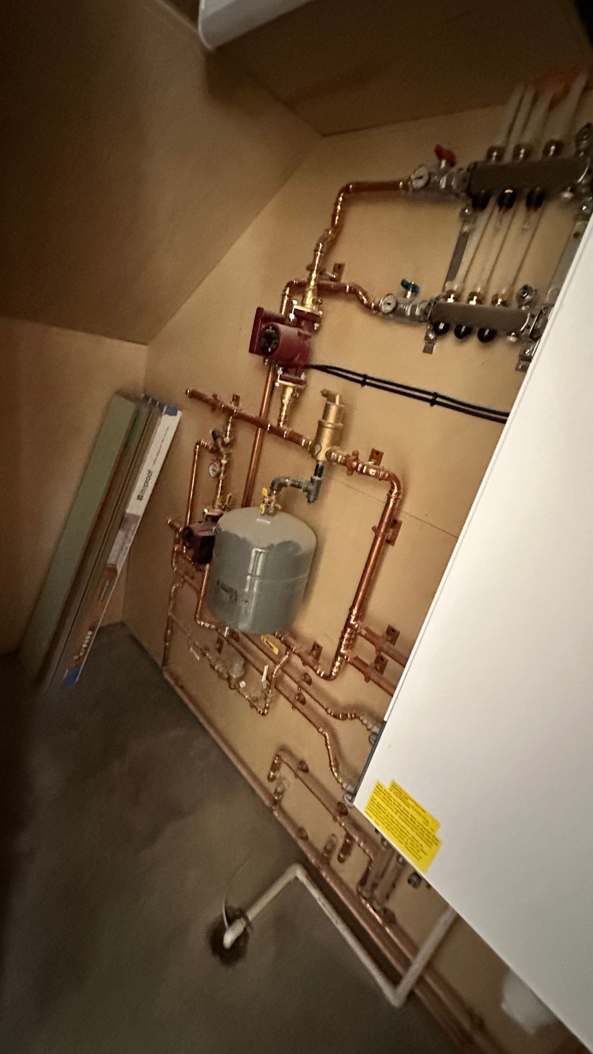 Pipes and boiler system in a utility room.