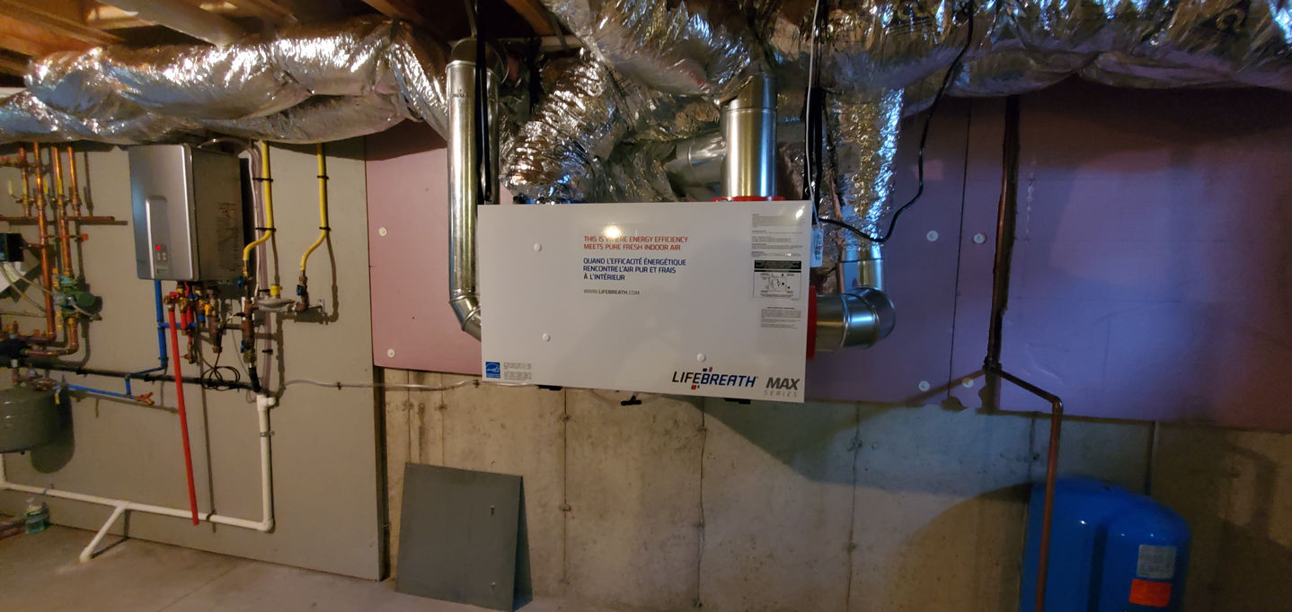Small HVAC unit installed in a basement setting.