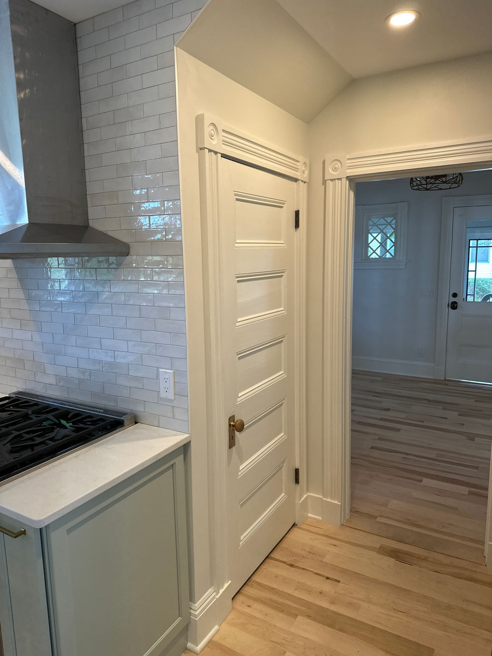 Kitchen with white cabinets and wooden floor.