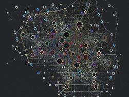 Knowledge graph/abstract network visualisation on a dark background, showing a dense web of fine, map-like lines and multicoloured circular nodes.